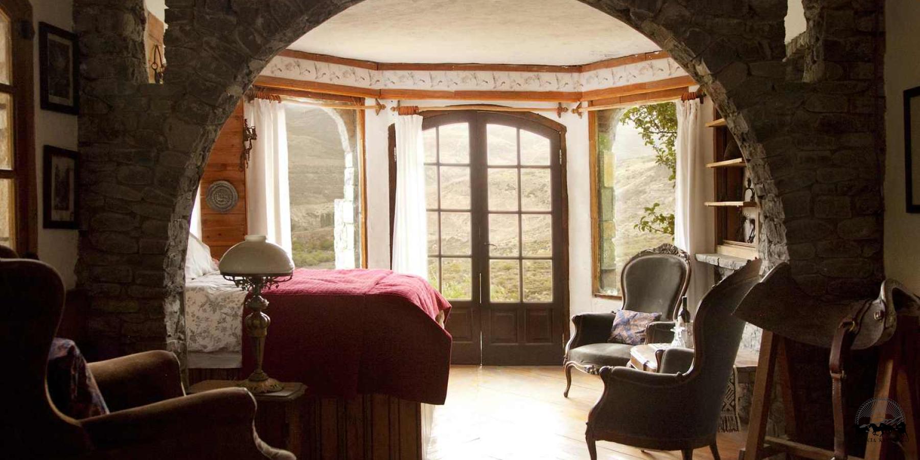 Image of the handcrafted stone arch and french doors in the Castle Room at Estancia Ranquilco